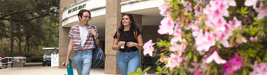 Students walk by azaleas after leaving the Pace Library Coffee House.