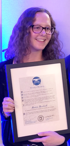 Student holding a framed award certificate
