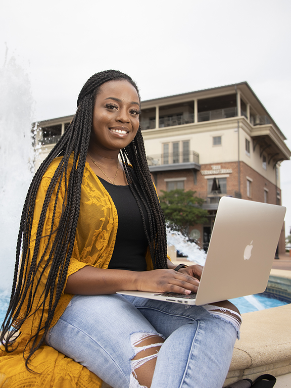 Online student smiling with laptop