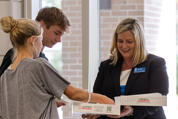students grabbing donut with dean