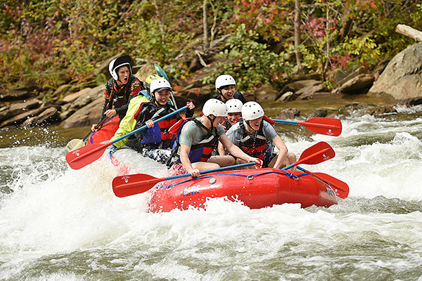 Group of students going down a water rapids.