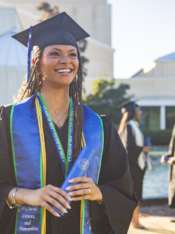 Graduating student smiling in cap and gown