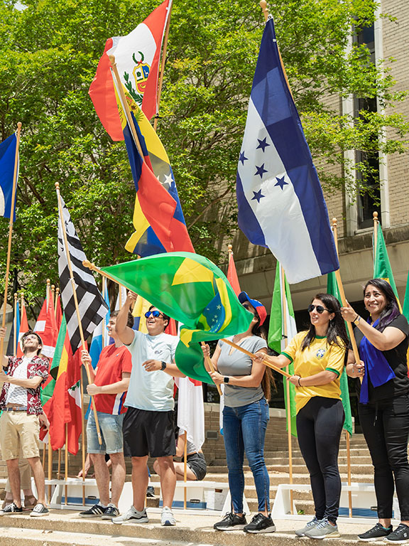 Students waving flags from different nations at the 2022 Global Block Party