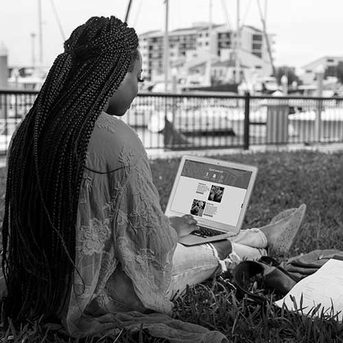 student working on a laptop on palafox pier in downtown pensacola