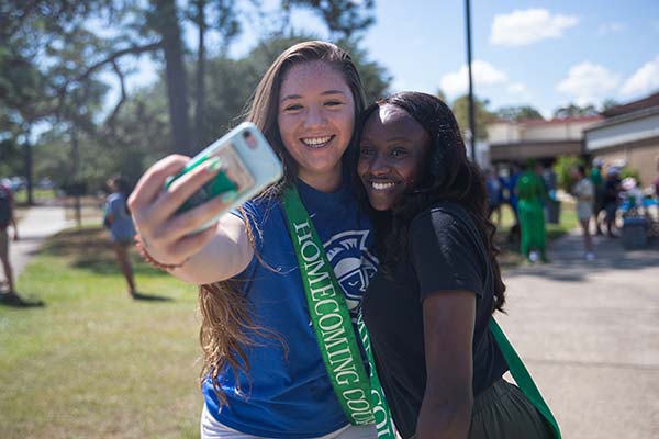 two students taking a selfie at a uwf homecoming event