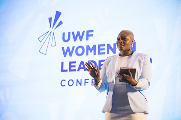 Speaker at the UWF Women in Leadership Conference holding a tablet in their left hand.