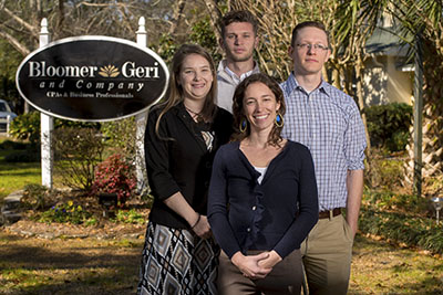 bloomer geri and company with four employees standing in front of the sign