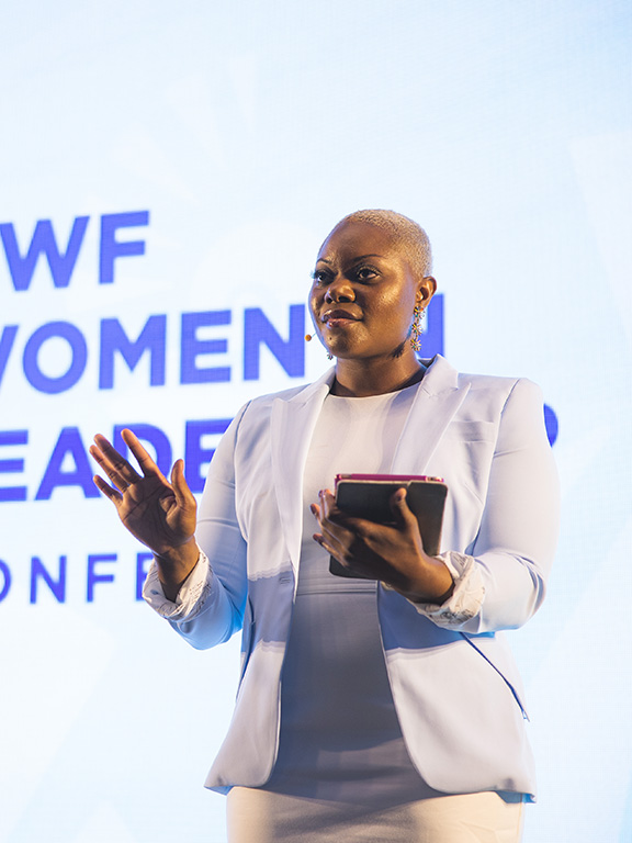 Speaker at the UWF Women in Leadership Conference holding a tablet in their left hand.