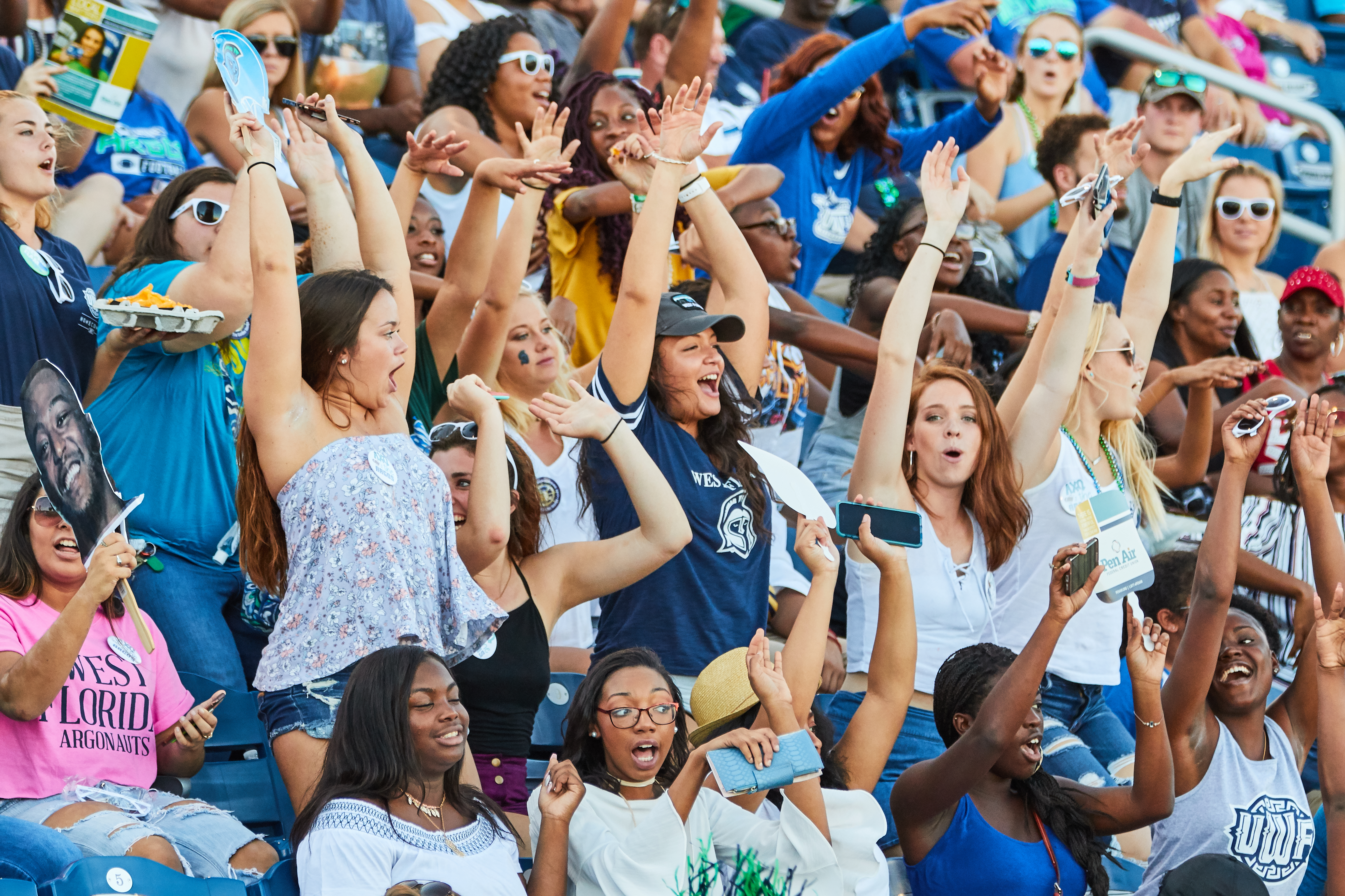 Students cheering in the stands during a UWF football game.