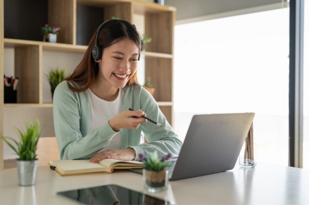 Young woman with headphones on looking at a computer