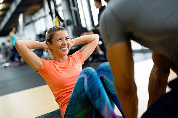 Physical trainer working with client in gym