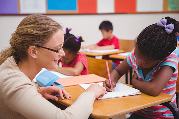 Teacher in the classroom working with student