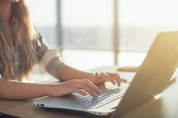 Hand on laptop typing