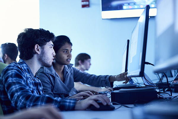 three data science students working in a computer lab