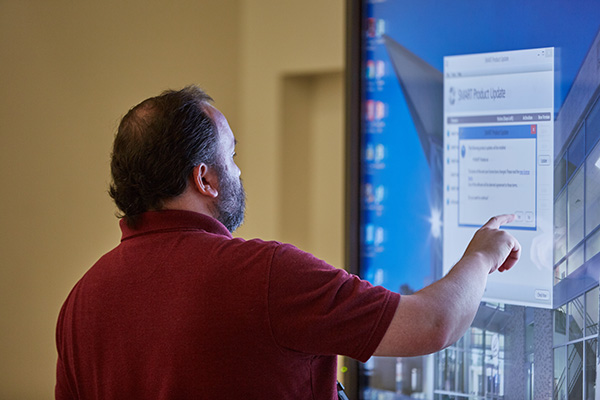 business student working on a large touchscreen display